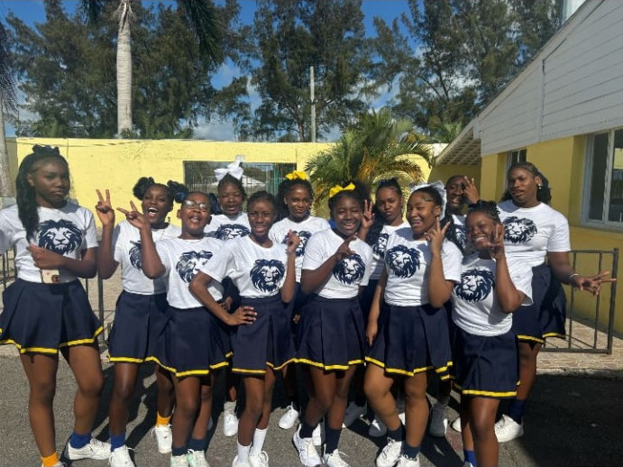 A group wearing matching Lions shirts and navy-and-gold skirts gathered outdoors.