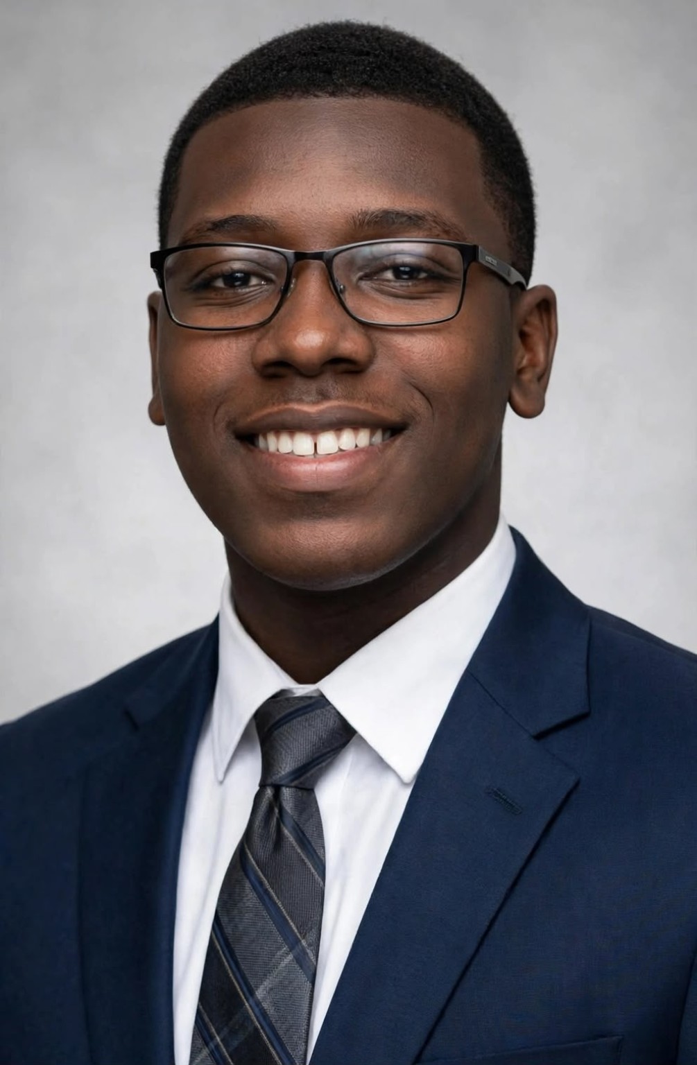 Stevenson Petit-Bose, Secretary at Royalty Preparatory Academy, in a navy suit and glasses.